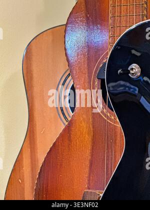 Three used guitars displayed in a store highlight the curvy shapes of the musical instruments. Stock Photo