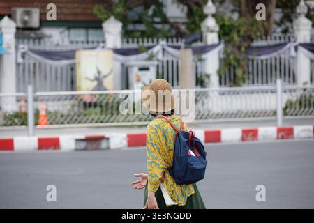 Female backpacker walking and exploring new city in Bangkok, tourists walking through local urban atmosphere, side profile. Stock Photo