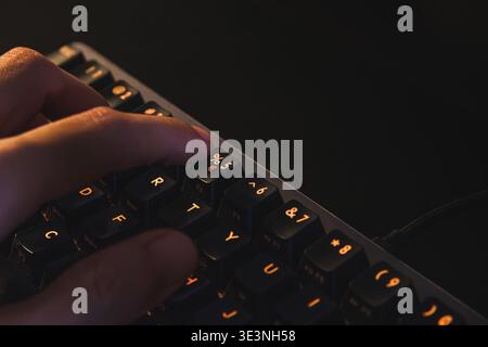 A detailed close-up shot of a person's index finger poised to press the percentage (%) symbol key on a mechanical computer keyboard. Stock Photo