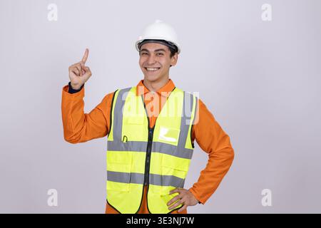 Happy worker in safety vest pointing up with one finger Stock Photo