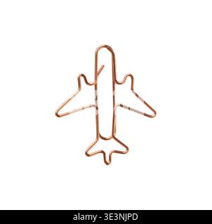 Airplane shaped paperclip made of copper metal isolated on light background. Minimal stationery object used as a creative design element and concept s Stock Photo