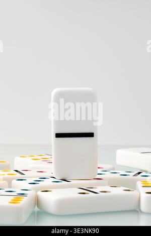 White domino stands out among scattered pieces during a game session at home Stock Photo