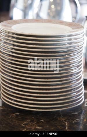 Stack of plates on a table in a restaurant Stock Photo
