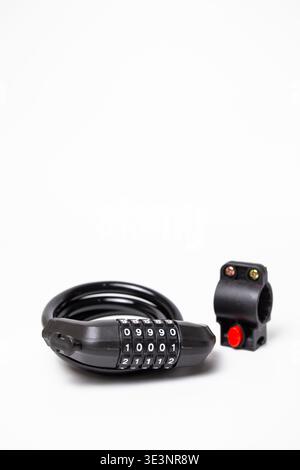 Studio product shot of a sturdy black combination bike lock with coiled cable and separate mounting bracket with red quick-release button. Stock Photo
