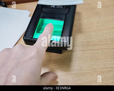 Kirov, Russia - January 29, 2026: A person places a finger on a scanner to verify identity while applying for official documents in a Russian governme Stock Photo