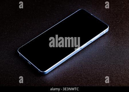 Lviv, Ukraine - March 24, 2026: Modern black smartphone lying on textured surface Stock Photo