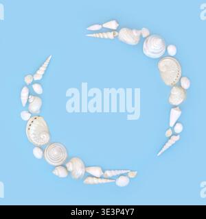 Seashell wreath of white and mother of pearl shells on blue background. Minimal zen abstract frame design, iridescent colors, coastal themed decor. Stock Photo
