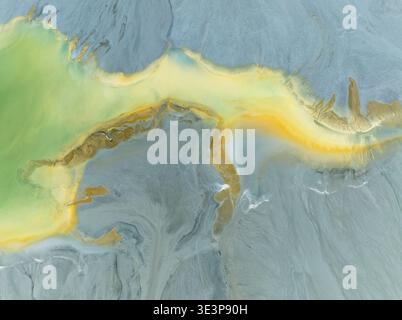 Abstract patterns in a waste pond in the mineral-rich area of the Rio Tinto mines. The colour is caused by oxidised iron minerals. Aerial view. Drone Stock Photo