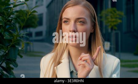 Close up pensive Caucasian business woman thinking deep thought outdoors city street female businesswoman entrepreneur creative developer manager Stock Photo