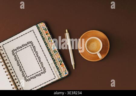 Planner, cup of coffee and pen on brown background. Autumn planning, productivity and organization concept. Flat lay style. Top view. Stock Photo