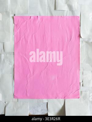A vibrant pink wheatpaste-style poster centered on a board covered in overlapping white thermal receipt paper. This gritty, "handmade" collage capture Stock Photo