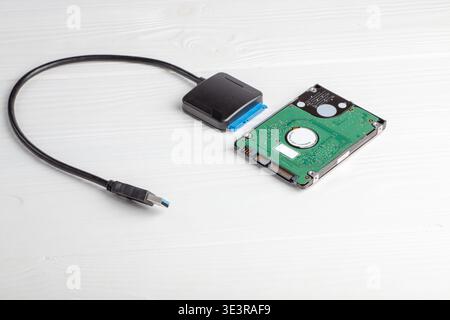 Hard drive connects to a USB adapter showing a clear view of the internal components. This device is used for data storage and transfer in different d Stock Photo
