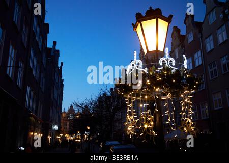 christmas decorations on traditional old town street lamp at sunset in winter gdansk poland Stock Photo