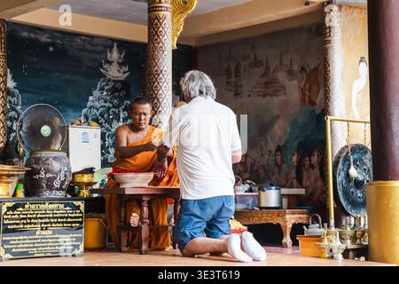 Ko Samui, Thailand, 22 March 2026: Tourist receiving blessing from Buddhist monk inside temple in Thailand Stock Photo