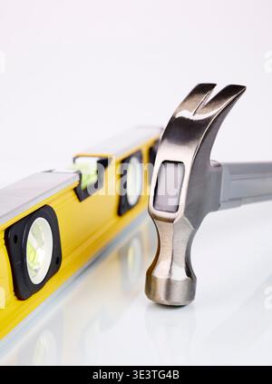 Spirit level and Claw hammer on a white background Stock Photo