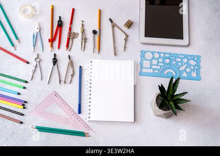 Geometry tools, pencils, and empty notebook on a desk. Drafting and engineering stationery flat lay for education. Stock Photo