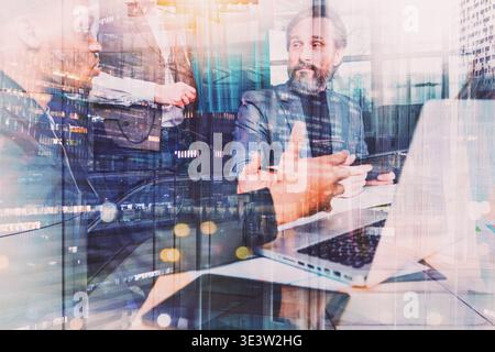 Business professionals engage in a discussion about project strategies in a modern office space during the day Stock Photo