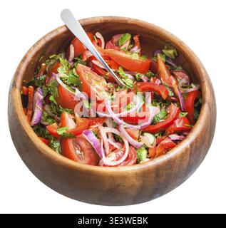 Spoon salad of fresh tomatoes, cucumbers and red onions, seasoned with olive oil, individually into a wooden bowl on a white background Stock Photo