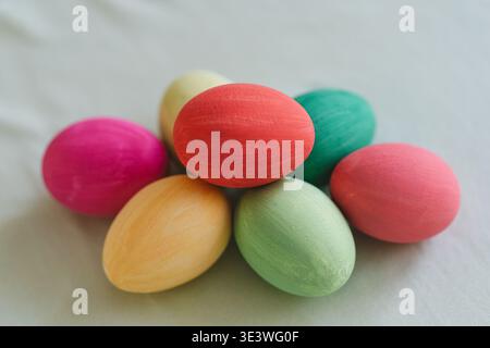 A collection of vibrant, multicolored Easter eggs displayed on a soft, neutral fabric surface, emphasizing the festive and cheerful spirit of the East Stock Photo