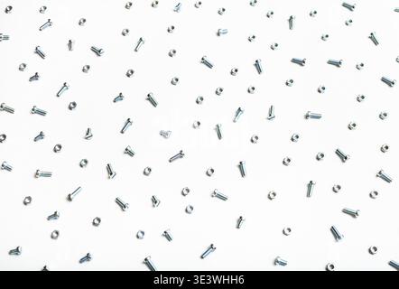 Top view of many steel screws and nuts on white background Stock Photo