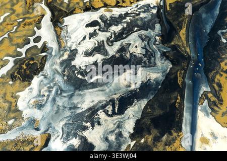 Abstract landscape showcasing swirling patterns in earthy browns, intense blacks, and soft grays. The intimate composition creates a mesmerizing visua Stock Photo