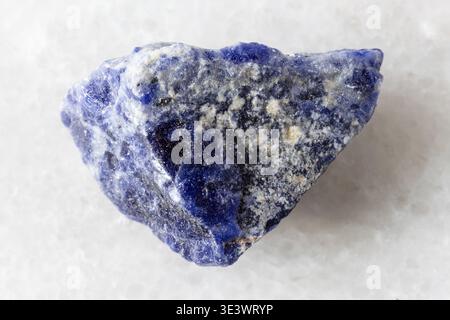 Close-up sample of raw sodalite rock on white marble background Stock Photo
