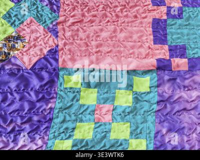 Textile background sewn square pieces of fabric in stitched silk patchwork scarf Stock Photo