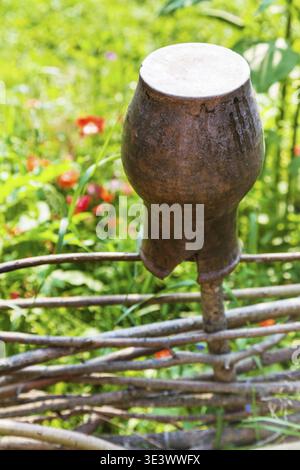 Rural landscape of broken clay pot up close at the willow fence Stock Photo