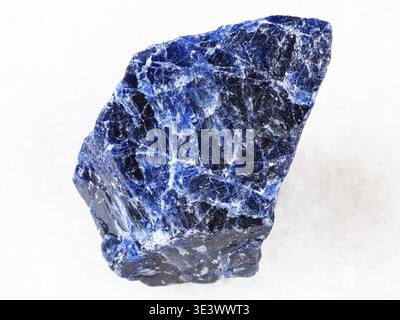 Macro shot of a natural rock sample of rough sodalite gemstone on white marble background Stock Photo