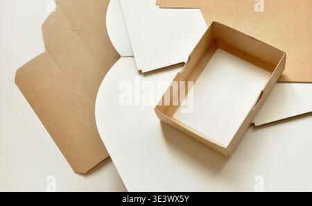 Cardboard brown boxes, unfolded, layered. Open box on top, blank space. Abstract artistic background. Sustainable packaging, packaging templates Stock Photo