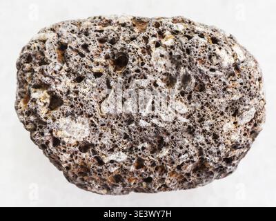 Macro shot of a natural rock sample of brown pumice on a white marble background from Sicily Stock Photo