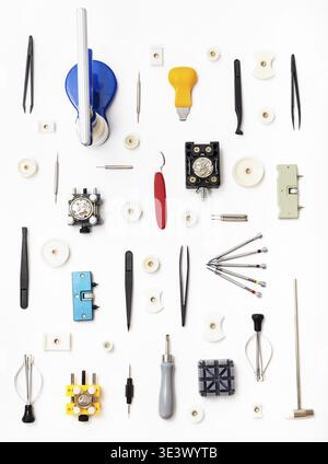 Watchmaker workshop Vertical ornament made from various watch repair tools on white background Stock Photo