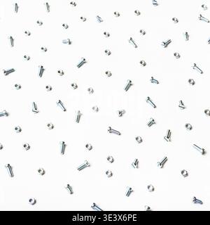View from above of small steel screws and nuts on white background Stock Photo