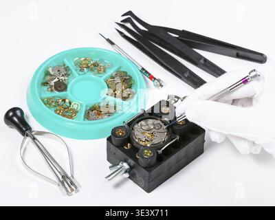 Watchmaker workshop repairing old mechanical clocks on white table Stock Photo