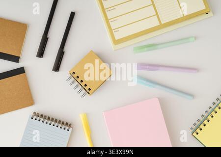 Office desk flat lay with notebooks, planner and colorful pens on white background. Planning concept. Pastel aesthetic. Creative workspace backdrop id Stock Photo