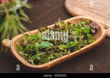 Wooden tray of freshly harvested green wild herbs for tea infusion Stock Photo