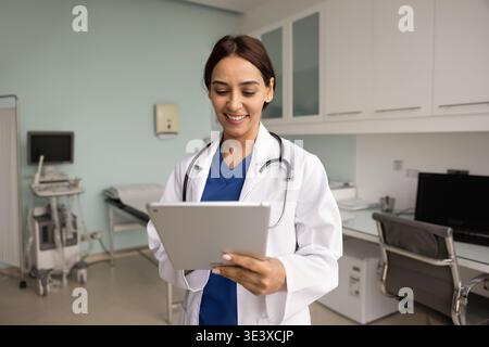 Young 35s Lebanese female physician doctor working on tablet Stock Photo
