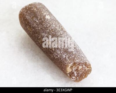 Macro shot of a natural rock sample â€” thunder stone, petrified rostra on white marble background Stock Photo