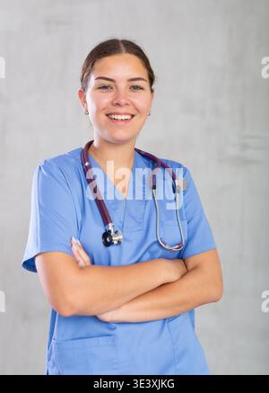 Smiling medical physician doctor in uniform posing on grey background Stock Photo