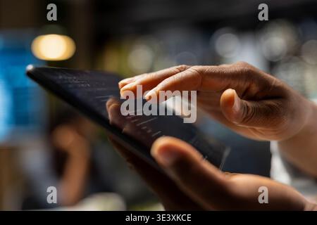 Close up of technician coding with tablet in startup office, refining machine learning models to enhance automation. IT professional using coding platform on device in Silicon Valley workplace Stock Photo