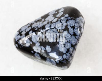 Macro shot of a natural rock sample of snowflake obsidian gemstone on white marble background from the USA Stock Photo