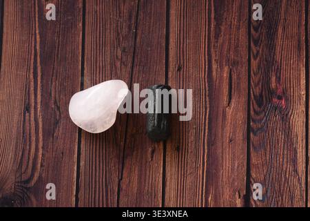 Tourmaline and rose quartz crystals placed on a rustic wooden table, showcasing natural textures and soft light. Ideal for themes of healing energy, l Stock Photo