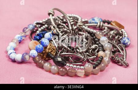 Frosted natural blue and pink agate gemstone necklace and metal chain on pink textile background Stock Photo