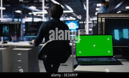 Data center engineer working on neural network software development on chroma key laptop. Server room IT specialist implementing machine learning technology using isolated screen notebook, camera A Stock Photo