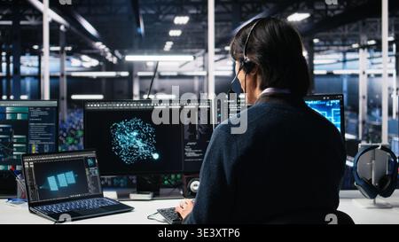 Data center system administrator using AI assistant to provide user technical support. Server room IT specialist managing live support calls assisted by artificial intelligence LLM, camera A Stock Photo