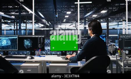 Data center technician uses machine learning algorithms on isolated screen PC to analyze datasets. Server hub worker uses AI neural networks on chroma key computer to recognize data patterns, camera A Stock Photo