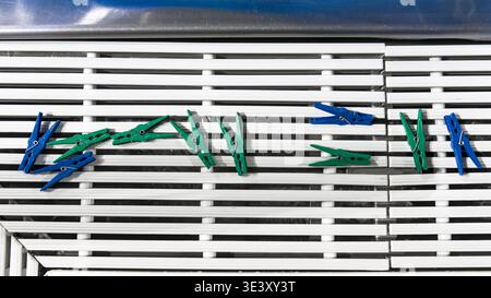 Blue and green clothespins neatly arranged on a white grid in a clean, minimal composition. Stock Photo