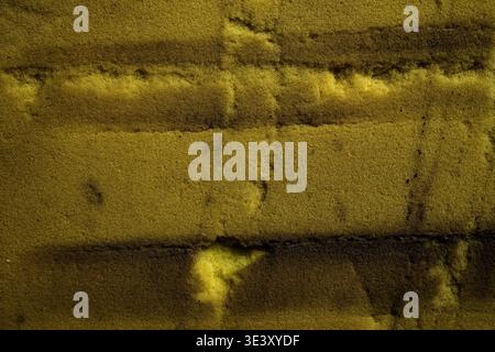 Weathered yellow porous foam texture. Gritty industrial surface for 3D mapping, sustainable packaging design, and worn material concepts. Stock Photo