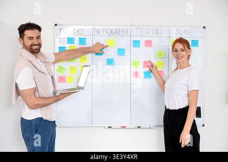 Young people discussing business plan on Kanban board in office Stock Photo