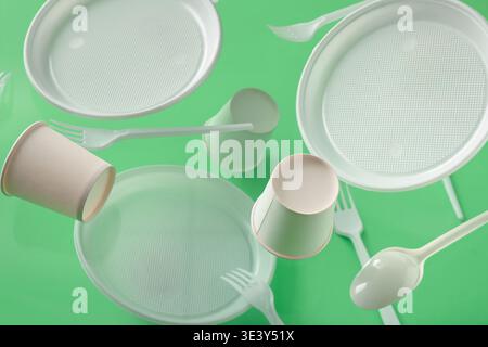 White plastic tableware levitating on green background Stock Photo